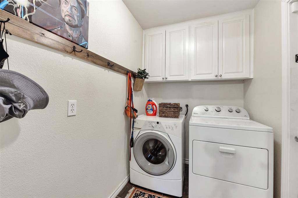 Indoor laundry room with hooks and cabinets.