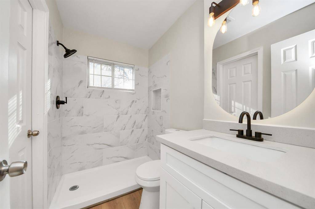 Fully renovated full bathroom with built-in LED mirror and custom stone vanity sink.