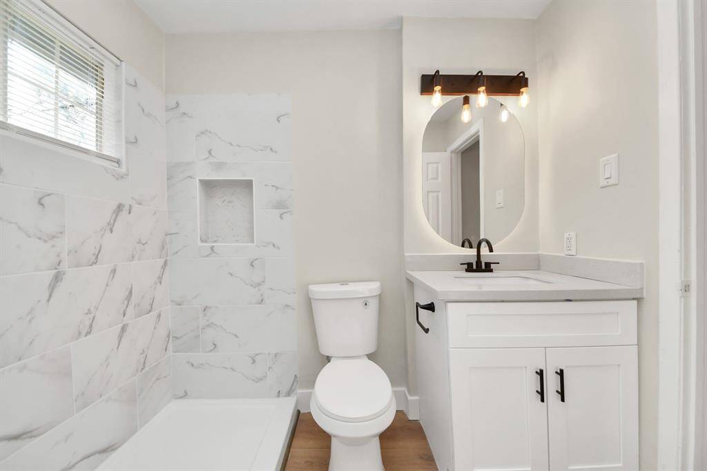 Fully renovated full bathroom with built-in LED mirror and custom stone vanity sink.