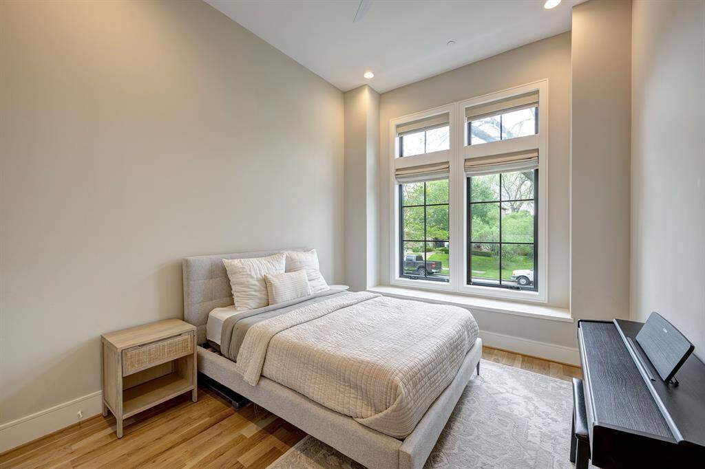 Downstairs guest suite features soaring 12-foot ceilings, white oak hardwood floors, and a spacious closet. Guests will enjoy the convenience of a private en-suite bathroom, making this suite ideal for long-term stays or multigenerational living.
