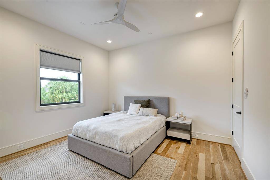 This secondary bedroom offers a unique and thoughtful connection to the primary suite through one of its two walk-in closets—ideal for use as a nursery, home office, gym, or even an expanded primary closet. Outfitted with white oak hardwood flooring and a spacious walk-in closet, this room also includes its own private ensuite bathroom, making it a perfect guest retreat or versatile extension of the primary suite.