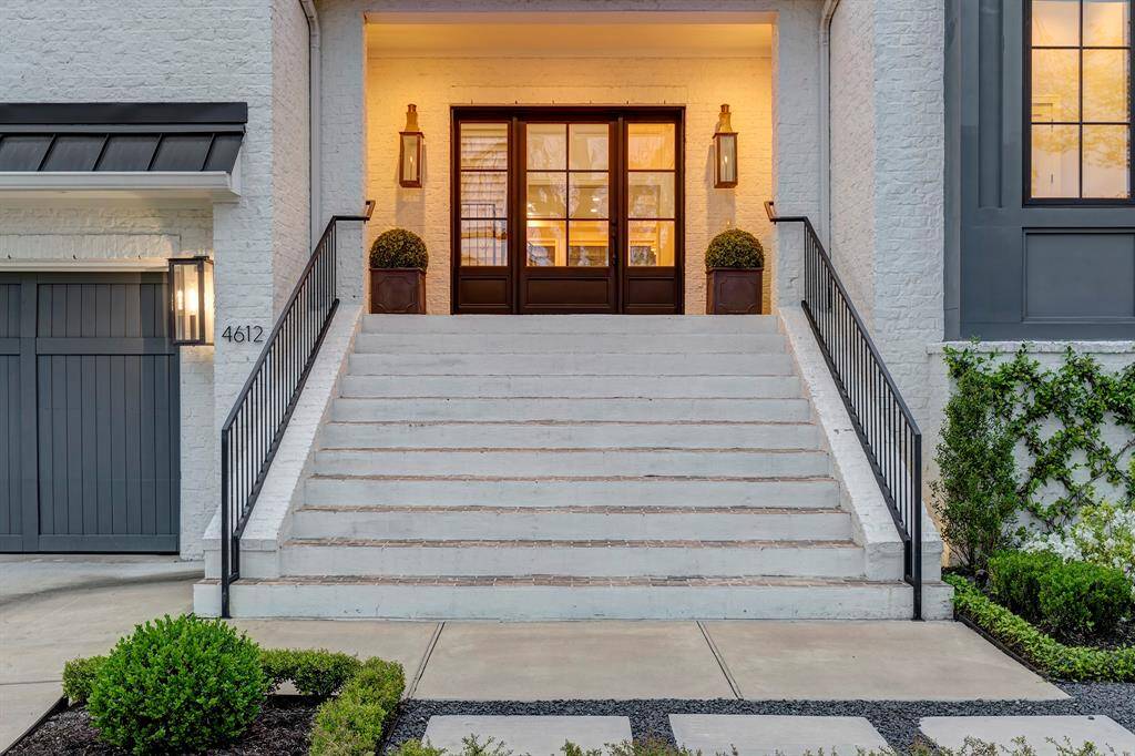 A grand, wide staircase leads to a welcoming covered entryway, framed by two 36-inch gas copper lanterns. The entrance is crowned with an impressive custom metal-and-glass entry door—9 feet wide and 8 feet tall, with a 4-foot opening.