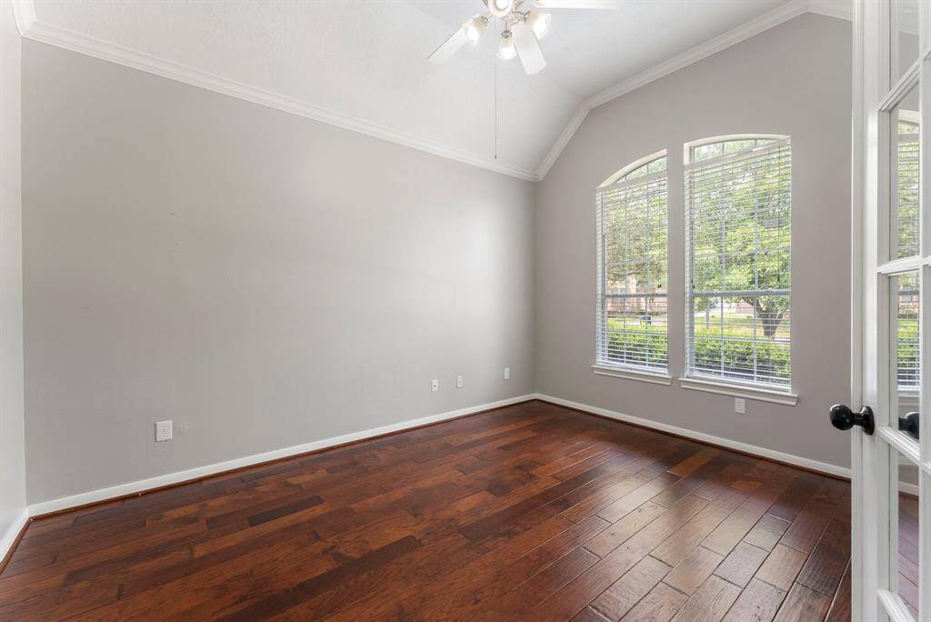 Formal study with high vaulted ceilings, glass french doors, hardwood floors and lovely front yard views.