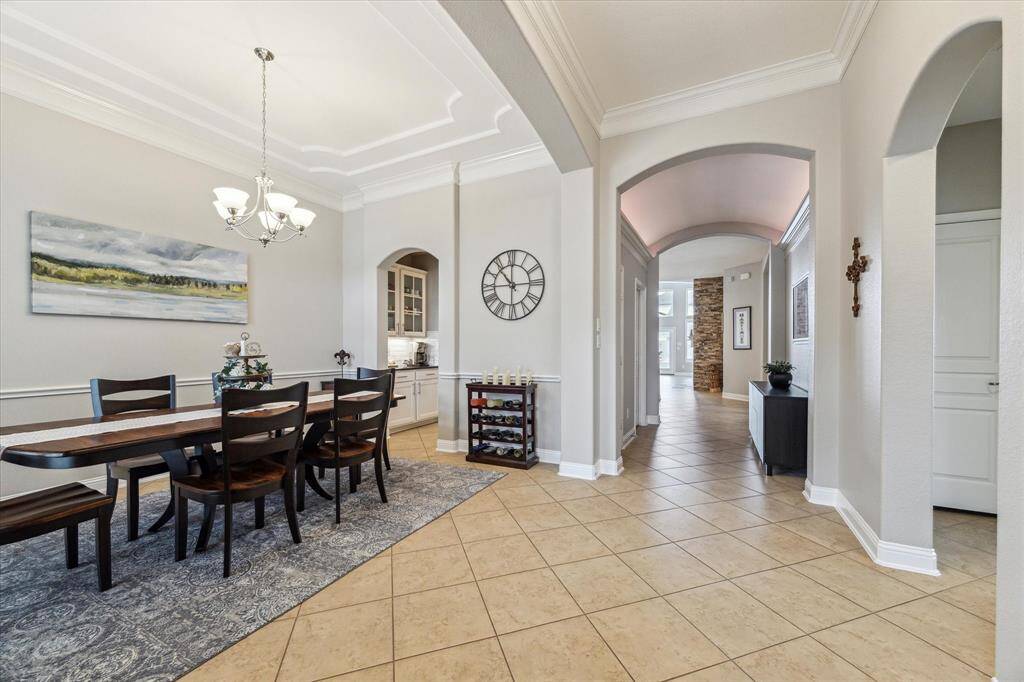 The grand foyer area offers extra wide entry, high ceilings with crown molding and barrel style ceiling.