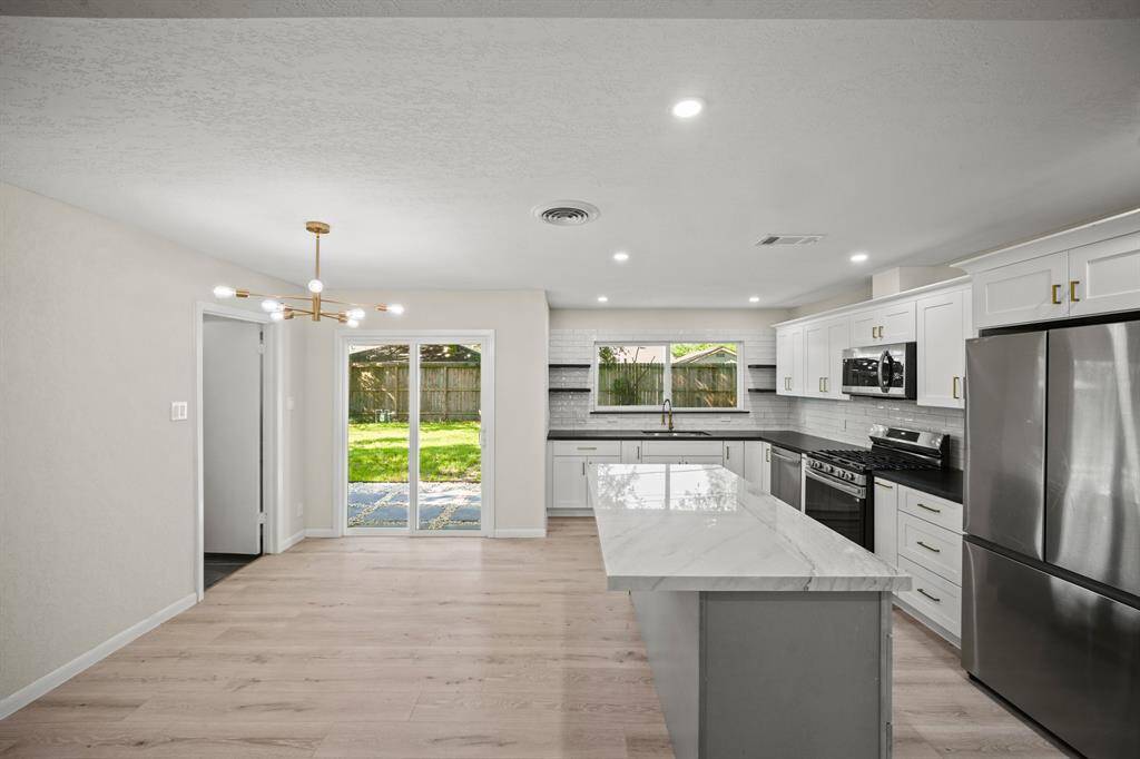 This Modern and Stylish Kitchen features a New Samsung Stainless Steel French Door Style Refrigerator, New Wide Plank White Oak Hued Waterproof Engineered Floors*, Fresh Designer Paint, and New Recessed Lighting (*per Seller).