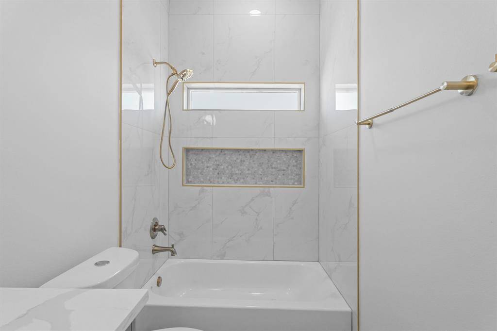 The shower/tub combo is complete with recessed lighting, and gorgeous tile walls.