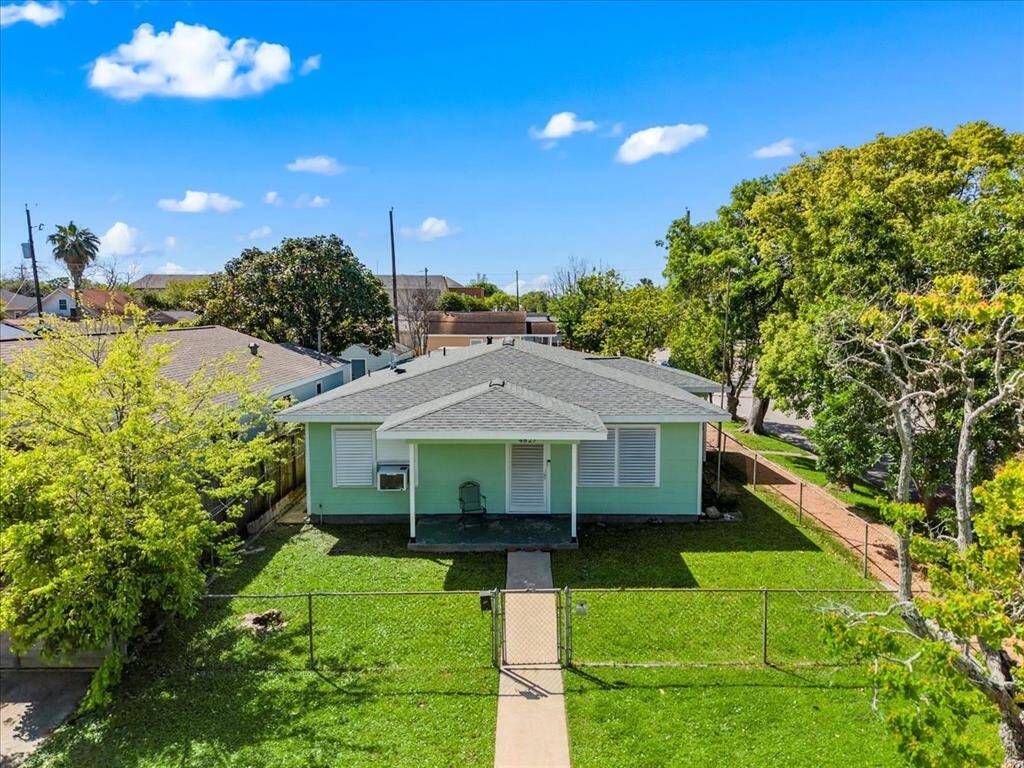 Charming home on Avenue Q 1/2, featuring a welcoming front porch, lush green lawn, and mature trees. Ideal for those seeking a cozy, peaceful retreat.