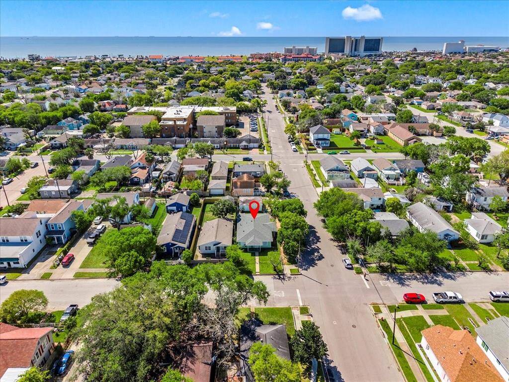 Located in a residential area near the coast, featuring a well-kept neighborhood with tree-lined streets and a view of the ocean in the distance. The highlighted house is centrally located, offering easy access to local amenities and the waterfront.