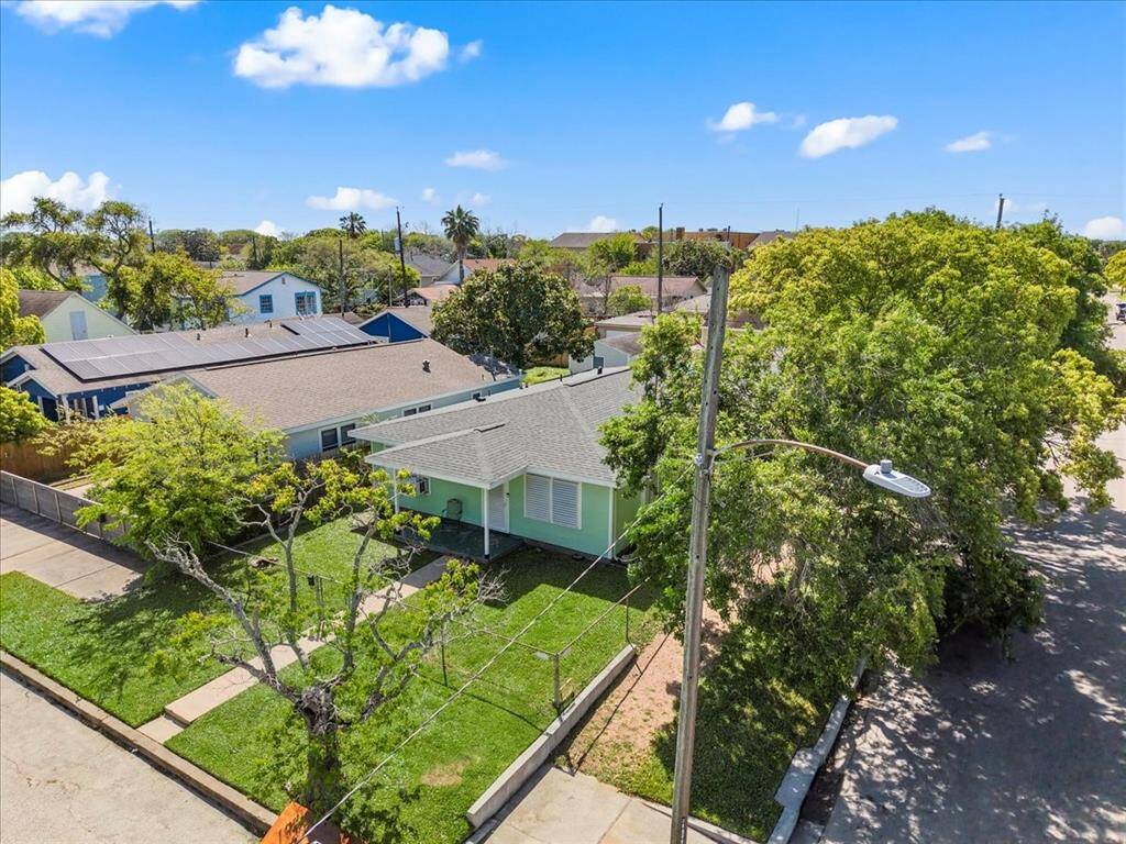 Nestled on a corner lot. The property features a well-maintained yard with mature trees providing shade.