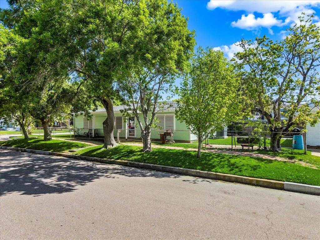 Spacious home, spacious yard, and shaded by mature trees. The property features a fenced area and a welcoming front porch, perfect for relaxing outdoors. Located on a quiet residential street.