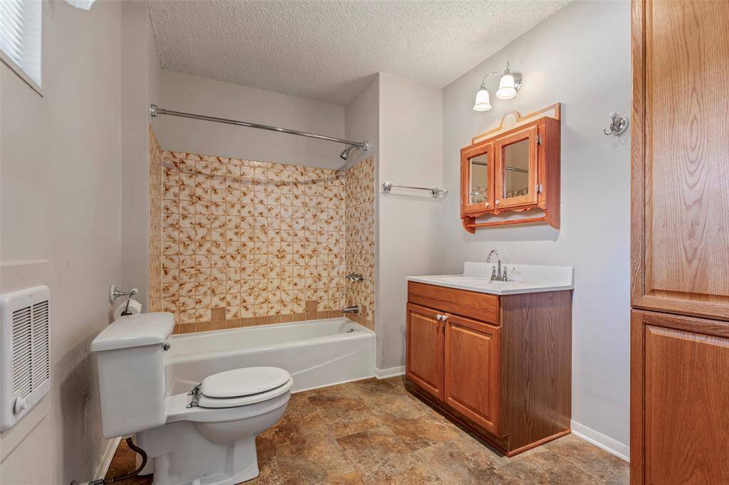 Shared bathroom includes area for washing machine and dryer.