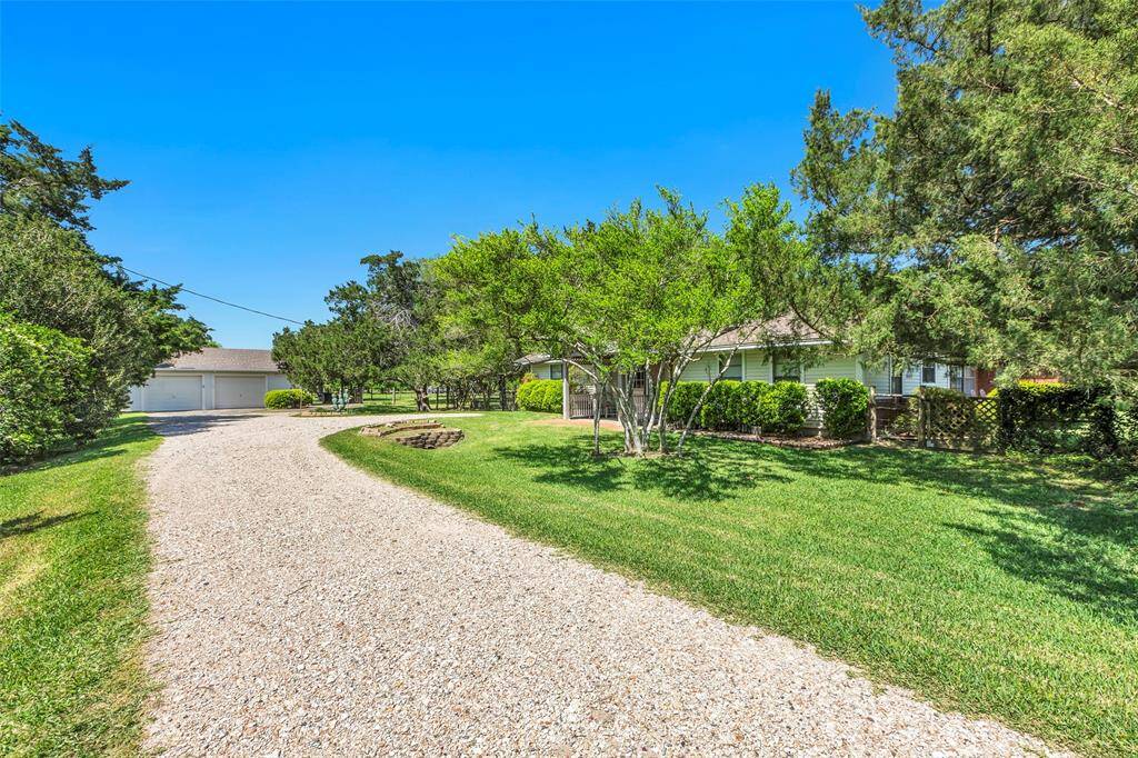 View up driveway to house and garage on left.