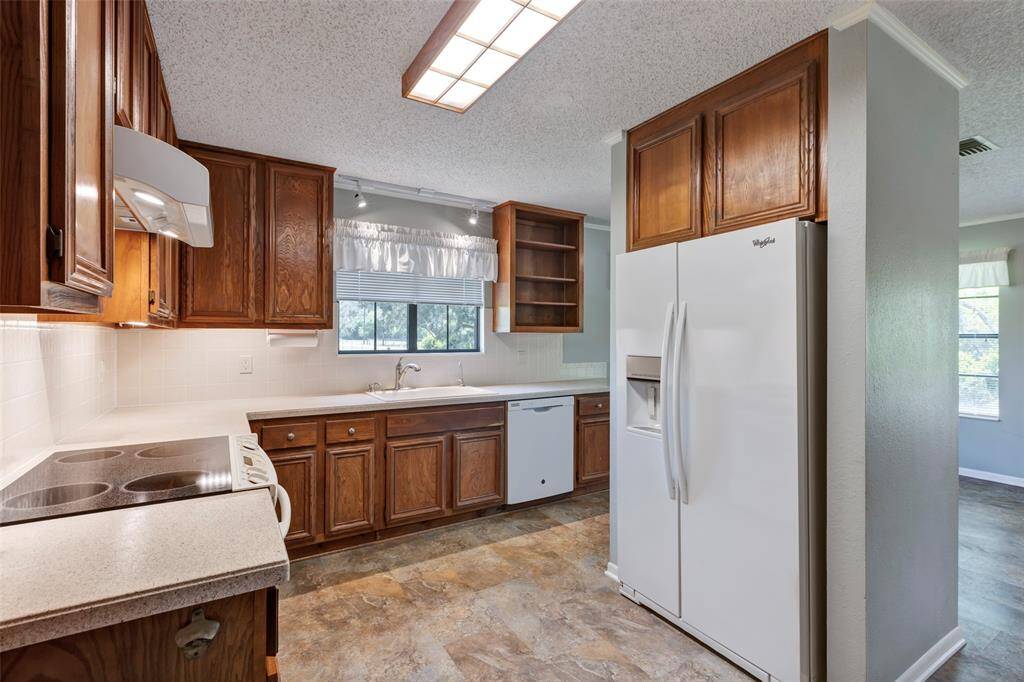 In the kitchen you will find a smooth surface cooking range and hardwood cabinetry.