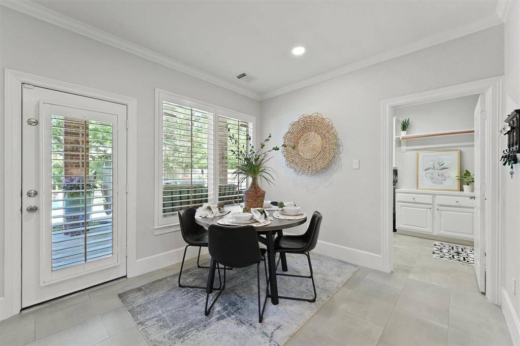 The breakfast room features plantation shutters on the windows and door leading to the covered patio.