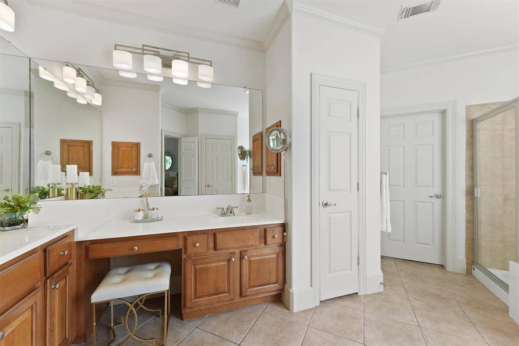 The en-suite bathroom features double sinks, a wall of mirrors, separate shower, and jetted soaking tub.