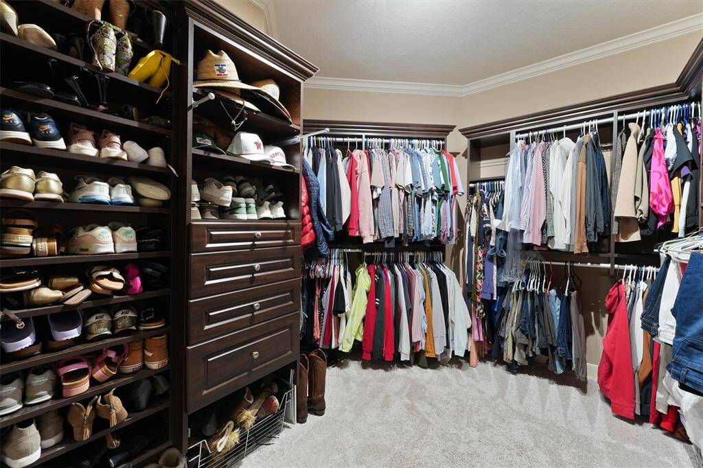 The custom walk-in closet has built-in clothes racks, drawers, and shelves to store your favorite clothes.