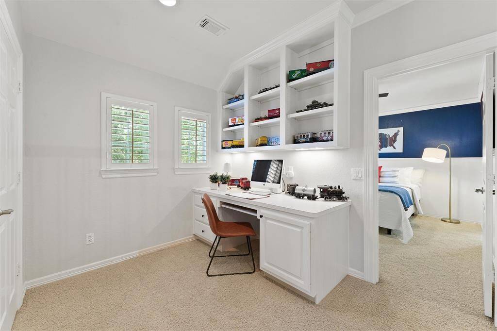 One of 4 upstairs bedrooms has a flexible study space outside of the room with built-in cabinetry.
