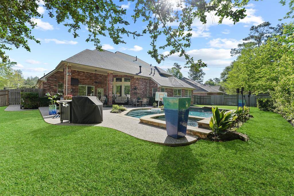 Impressive backyard space perfect for entertaining with a sparkling pool, hot tub, covered patio, backyard green space, updated landscaping, Wi-Fi controlled sprinkler system, new roof, and recently replaced fence.