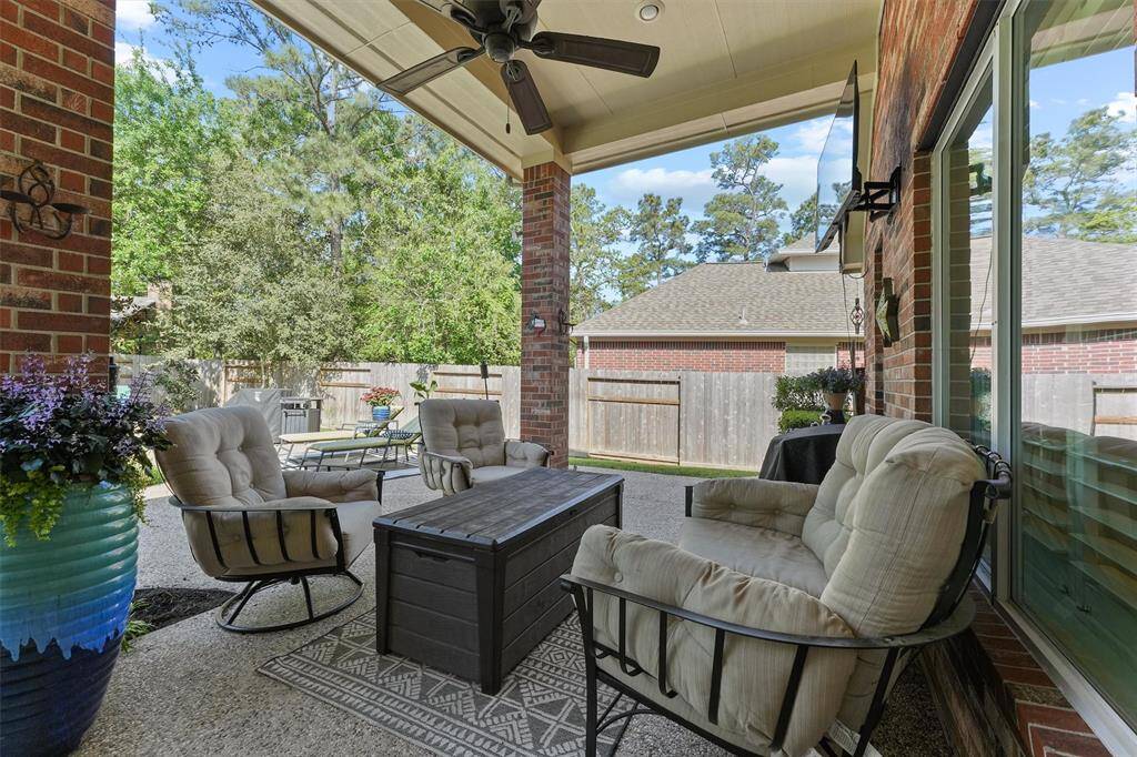 The covered patio overlooks the backyard oasis complete with an in-ground gunite pool.