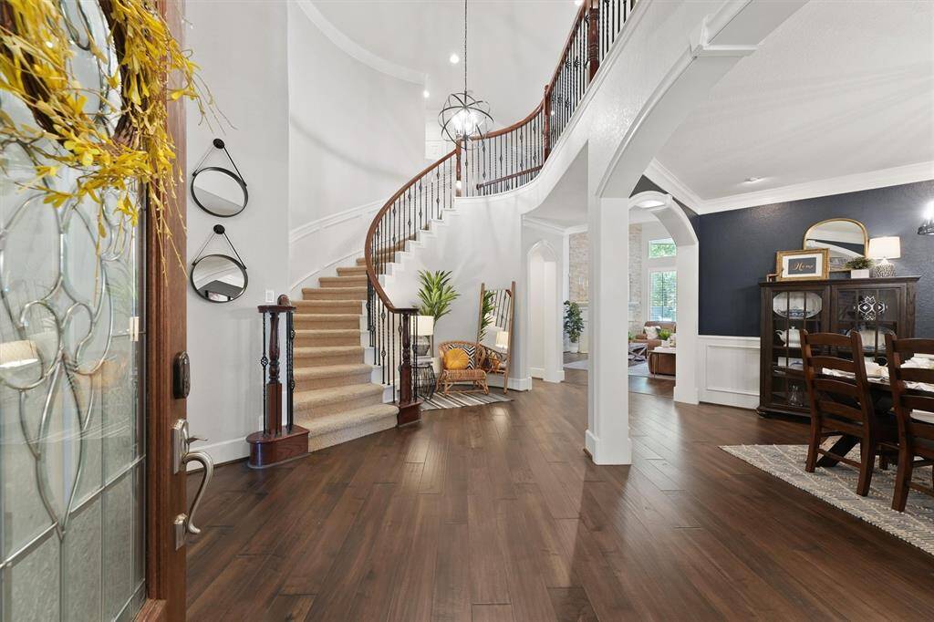 Upon entry, you are greeted with a stunning spiral staircase with wrought-iron railing, custom light fixture and engineered hardwood flooring leading you to the main living areas.