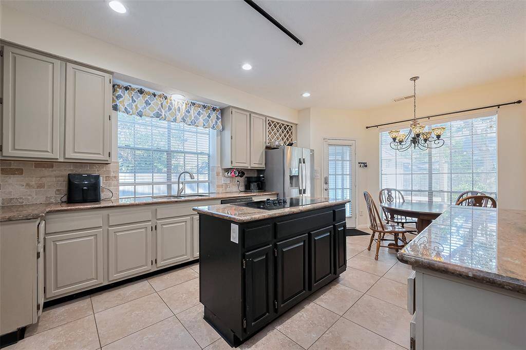 Spacious kitchen has cooktop island. Granite countertops.
