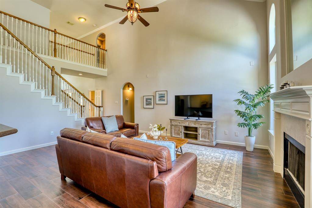 The living room is highlighted by soaring ceilings that open up the space, creating a stunning focal point. With ample natural light pouring in, the room feels expansive and airy, perfect for both relaxing and entertaining.