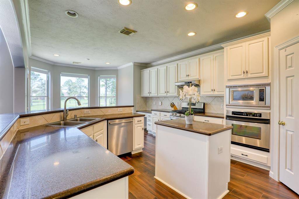 The open kitchen features sleek granite countertops and a center island, making it both functional and stylish. With ample counter space and modern finishes, it’s perfect for meal prep, casual dining, or entertaining guests