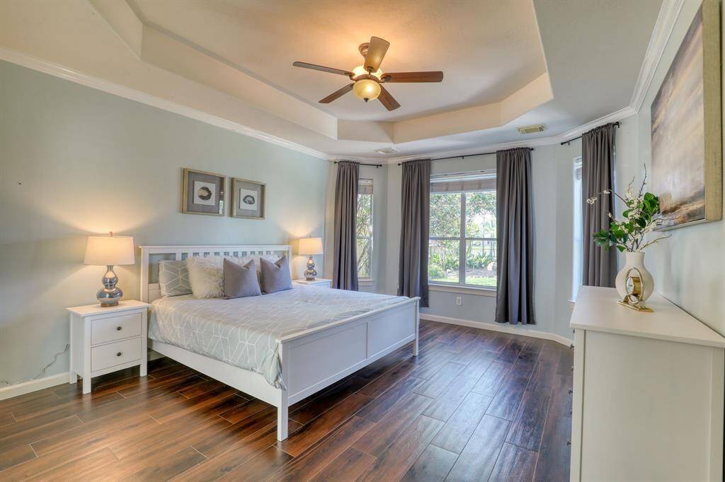 The spacious first-floor primary bedroom features elegant tray ceilings, adding depth and sophistication to the room.
