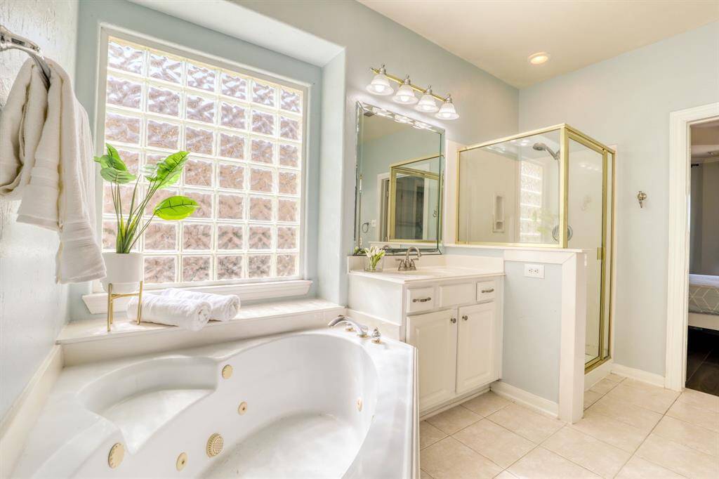 The primary bath features a separate shower and soaking tub, offering a spa-like experience.