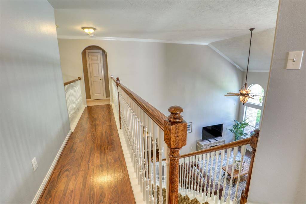 Upstairs hallway with access to secondary bedrooms and a view overlooking the living area below