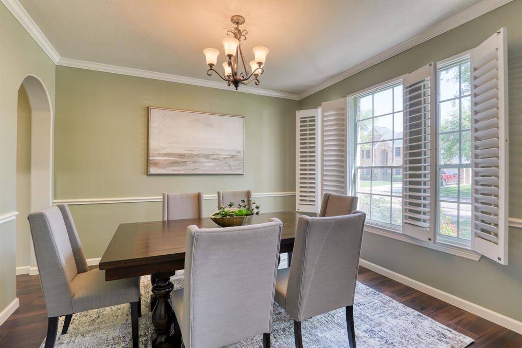 The formal dining room, conveniently located off the entry, is enhanced by elegant plantation shutters that allow for privacy while letting in natural light.