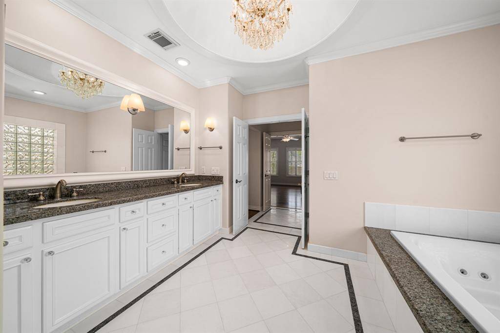 Primary bathroom with double sinks and granite counters.
