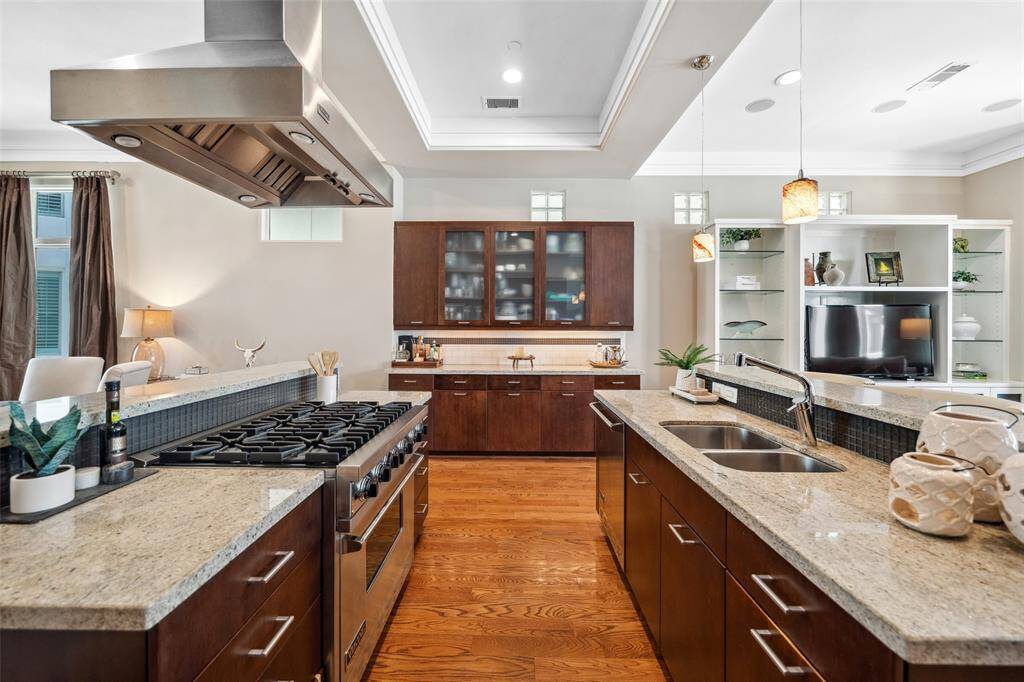 At one end of the galley-style kitchen, a built-in dry bar with glass-front cabinets offers the perfect spot for displaying glassware or creating a coffee or cocktail station.