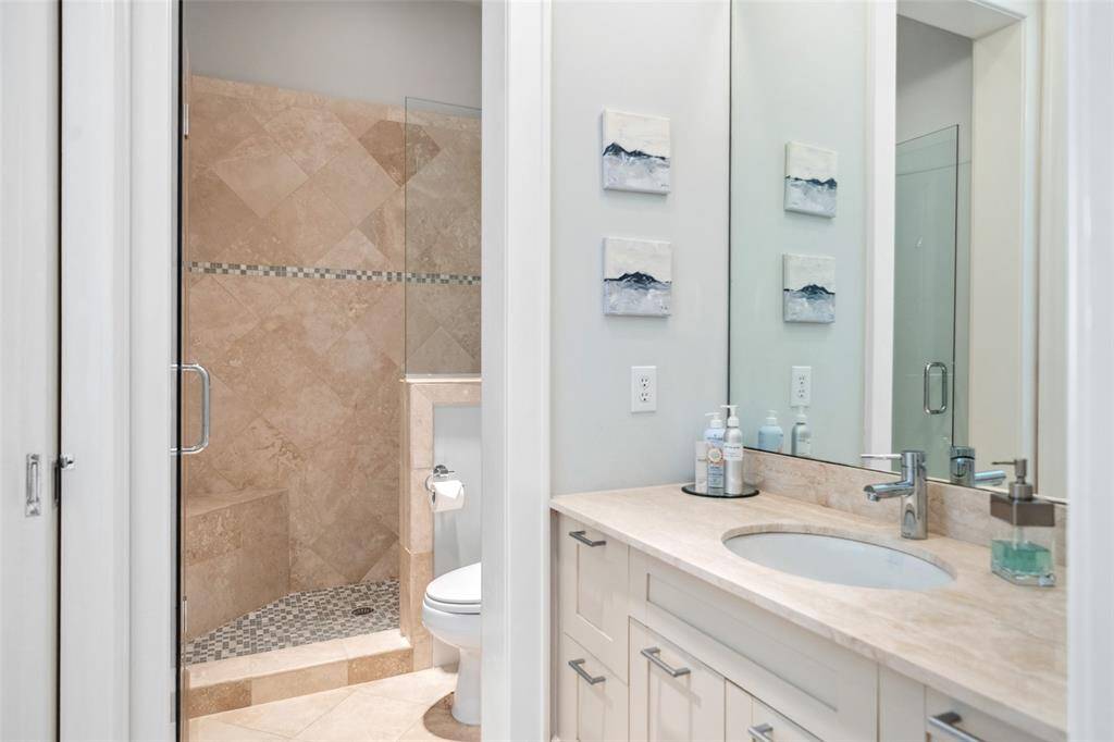 The en suite bath features a separate sink and vanity area. The shower and toilet are thoughtfully tucked away, making the layout both functional and guest-friendly.