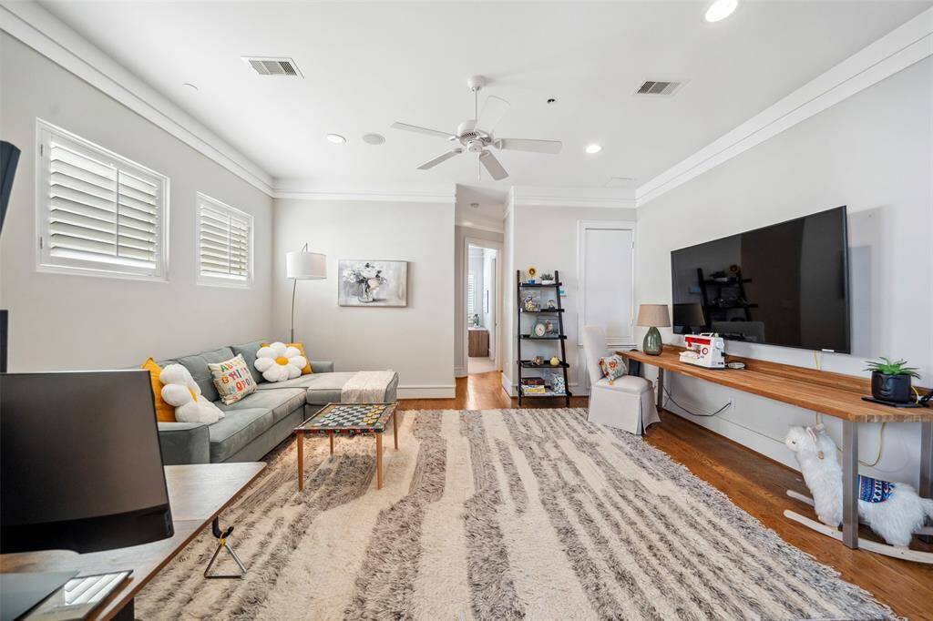 Back in the flex space, a built-in dry bar with beverage fridge and glass-front upper cabinets adds convenience and style. Glass doors open to the fourth-floor balcony, seamlessly extending the space.