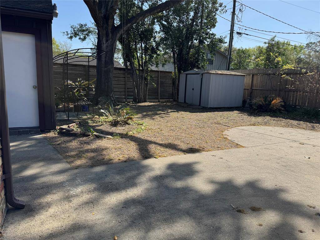 Spacious enclosed backyard with a storage shed. Door on the left opens to the detached 2 car garage.
