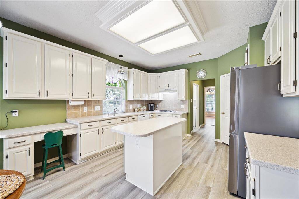 Spacious and efficient kitchen with ample cabinets, counter space, and a convenient workstation.