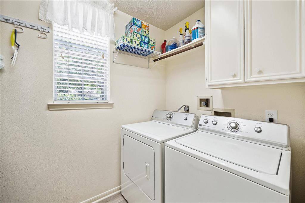 Conveniently located off the kitchen, this spacious utility room offers abundant storage and cabinetry.