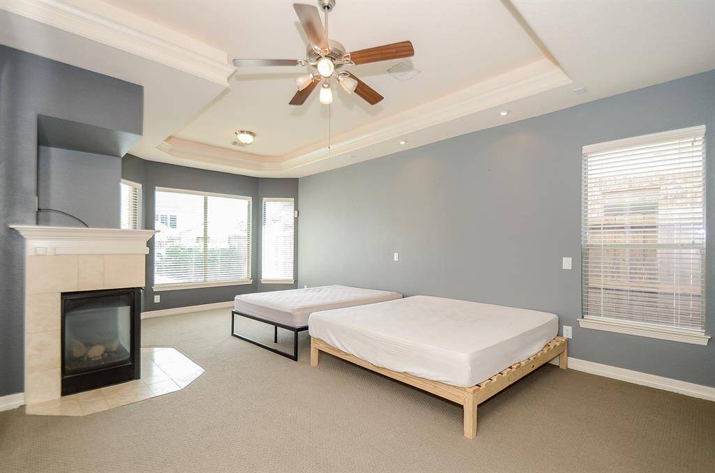 Elegant and romantic master suite has a wall of windows looking out at the pool in the sitting area.  Tray ceiling with crown molding, overhead reading lights and surround sound wiring.  There is a TV niche above the fireplace.