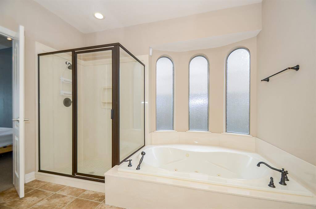 Master bathroom has a separate shower and oversized tub with hand sprayer.  Privacy rain glass offers natural light.