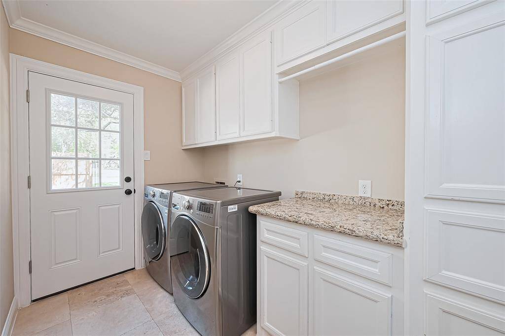 In-house laundry room with washer and dryer that will convey with the sale. There are custom cabinets and granite countertop folding area.