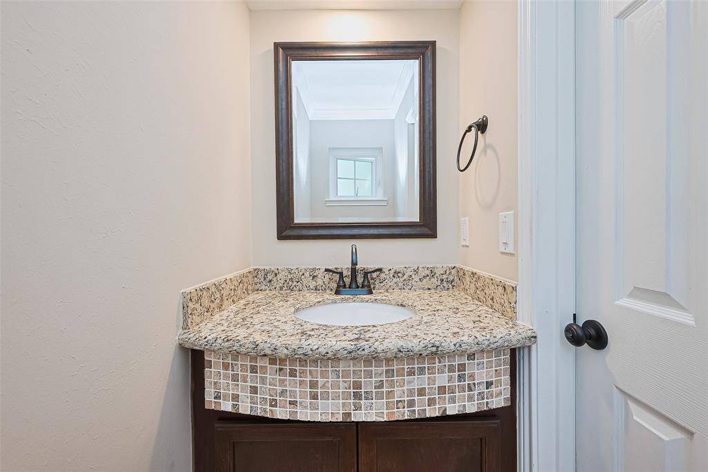 Convenient downstairs half bath with elegant granite countertop.