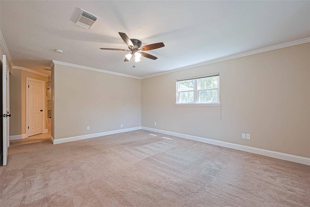 Spacious primary bedroom featuring carpet, a ceiling fan, and abundant natural light for a cozy retreat.
