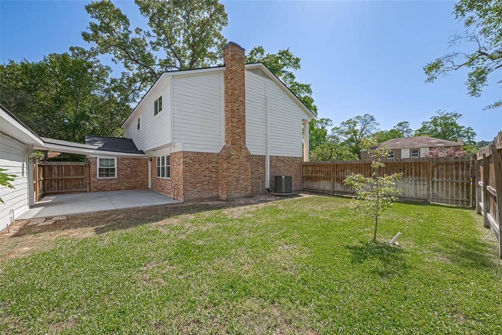 Spacious fenced backyard with a charming patio, perfect for outdoor relaxation and entertaining.