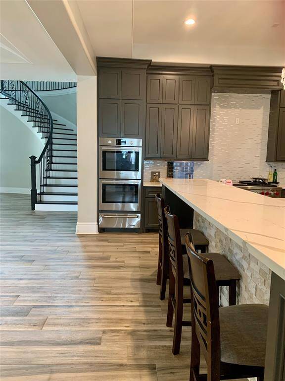 Closer view of the materials used for the island, backsplash and a view of the double oven.