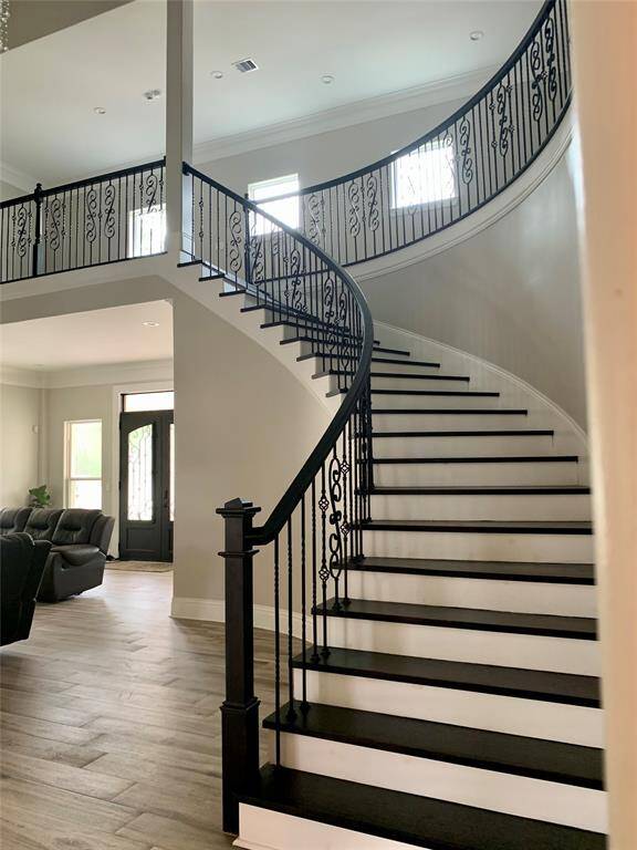 Impressive staircase leading to a surrounding open hallway upstairs.