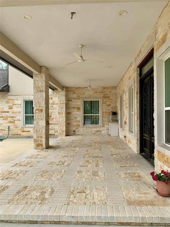The covered patio just outside of the custom door. This leads to an uncovered patio and garden including a pathway to another covered outdoor kitchen and dining area.