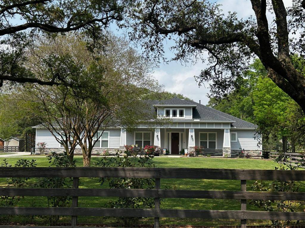 This modern one-story home welcomes you with a spacious front porch, lush landscaping, and a charming wood fence that adds just the right touch of privacy.