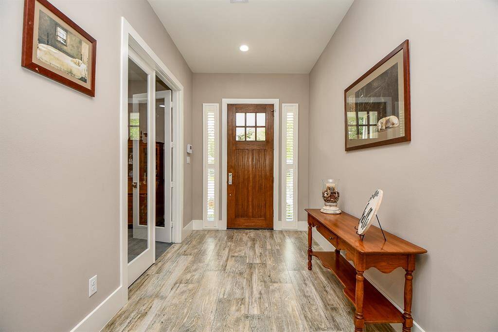 This welcoming entryway features side    lights with blinds and stylish wood-look tile flooring.  Energy efficient LED lighting throughout the  home.