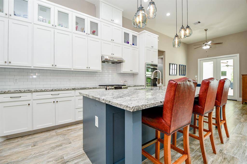 Features include elegant sleek white shaker cabinetry with soft-close drawers, granite countertops, and a large island with stylish pendant lighting with "Edison" light bulbs, breakfast bar and seating. Great for entertaining!